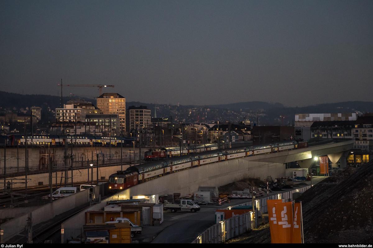 Kreuzung zweier HVZ-Dosto unterwegs auf der S19 am 15. Februar 2019 um 18:13 Uhr. Der Zug im Vordergrund Richtung Koblenz befindet sich gerade auf der Kohlendreieckbrücke. Auf dem Aussersihl-Viadukt am linken Bildrand ist zudem eine DPZ-Doppeltraktion der S24 zu sehen.