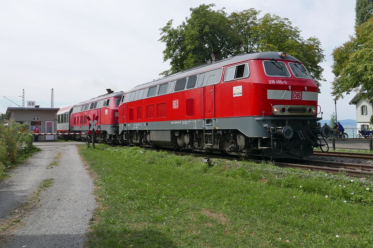 Kurz nach der bernahme der Wagen des IC 118, Innsbruck - Mnster(Westf), ziehen 218 495-0 und 218 456-2 den Zug am Lindauer Posten 48 vorbei in Richtung Friedrichshafen (11.08.2018).
