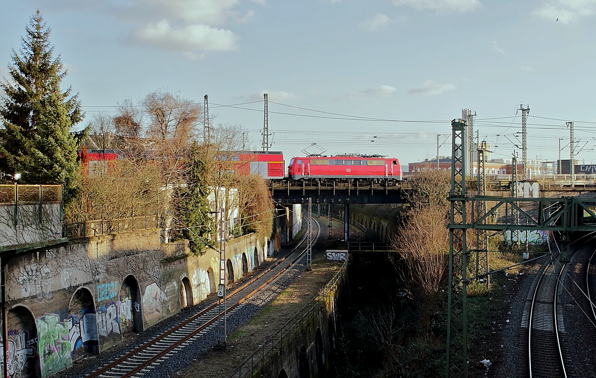 Kurz vor dem Düsseldorfer Hauptbahnhof überquert eine aus Richtung Wuppertal kommende 111 mit einem RE am 16.02.2018 die Güterumgehungsbahn von Lierenfeld nach Derendorf, die tieferliegende Trasse unterquerte früher die Hauptstrecke Düsseldorf - Duisburg (ganz rechts).