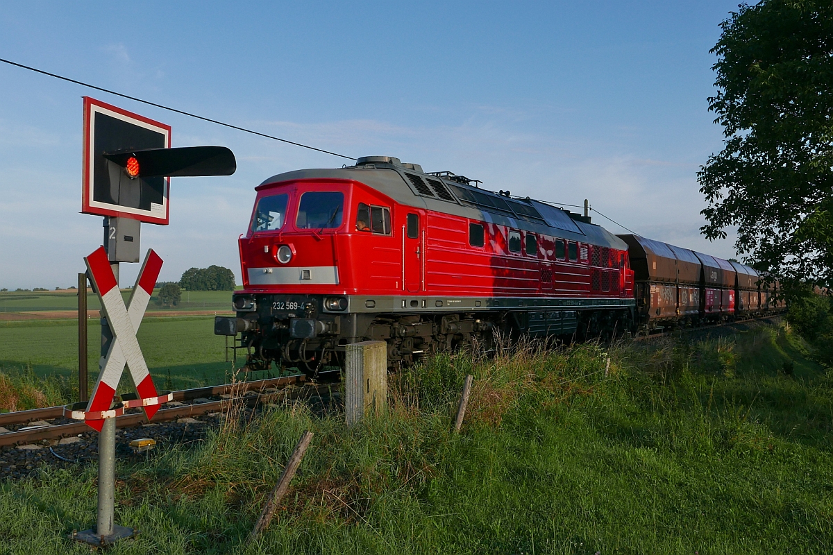 Kurz vor dem Zielbahnhof fhrt der von Friedrichshafen kommende “Roberger Kieszug“, am 28.07.2016 gezogen von 232 569-4, in der Nhe von Roberg am Fotograf vorbei.