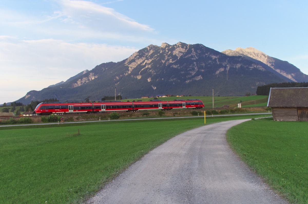Kurz vor Sonnenuntergang fährt die RB Mittenwald - München die Schmalenseehöhe in Richtung Klais hinab. Bahnstrecke 5504 München - Mittenwald Grenze beim Landhaus Wackerl - 15.09.2016