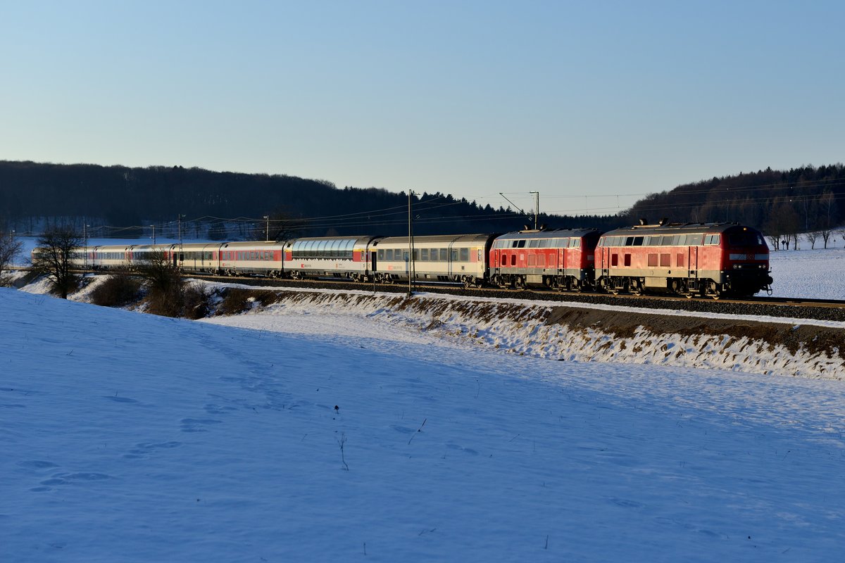 Kurz vor Sonnenuntergang fertigte ich am 25. Februar 2018 noch diese Aufnahme bei Kottgeisering an: Der EC 195 von Zürich HB fuhr im Streiflicht seinem Ziel München HBF entgegen. Zugloks waren die beiden Mühldorferinnen 218 421 und 423.