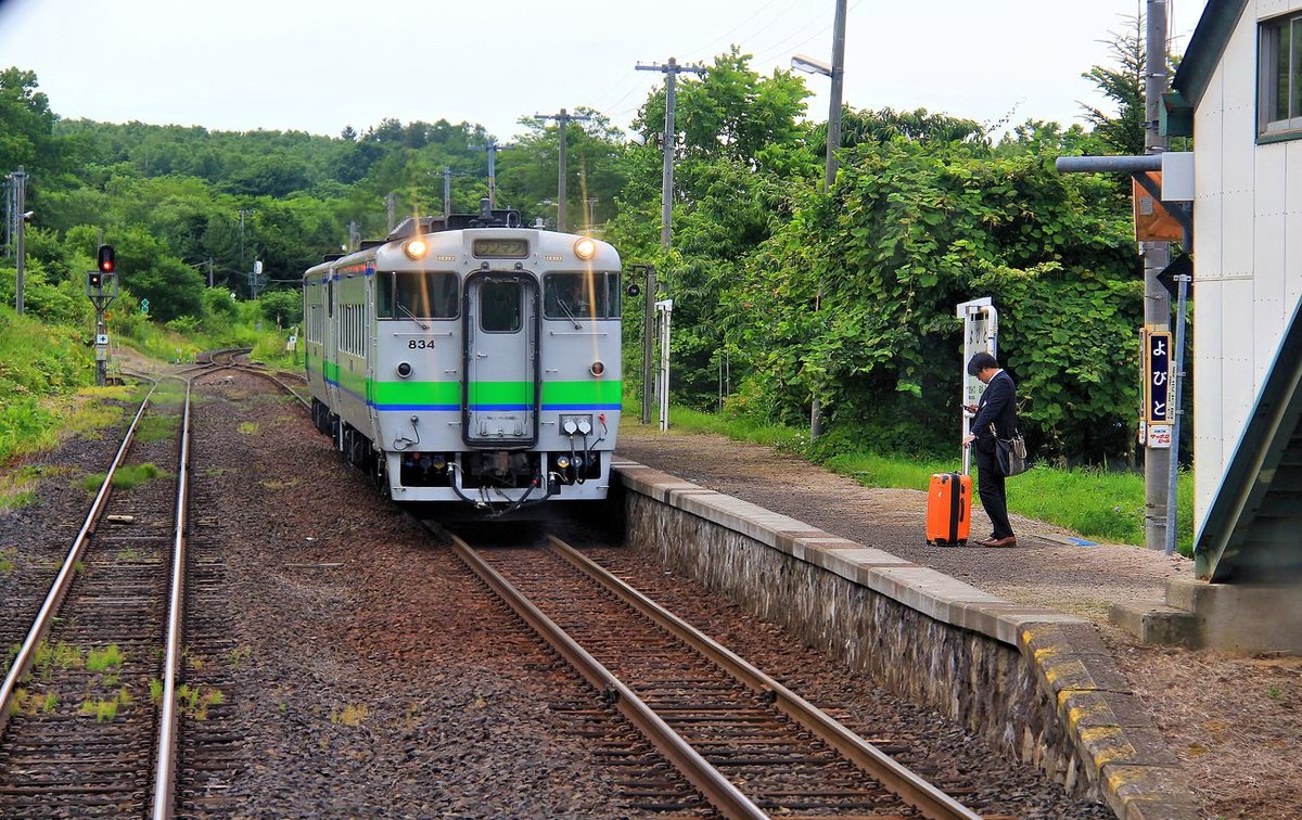 Lokalverkehr auf Hokkaidô: Mann mit orangem Koffer wartet im Nirgendwo auf einen Zug, der kaum je kommt. Yobito im äussersten Osten der Insel, Triebwagen KIHA 40 834 und KIHA 40 1735. 27.Juli 2016. SEKIHOKU-HAUPTLINIE   