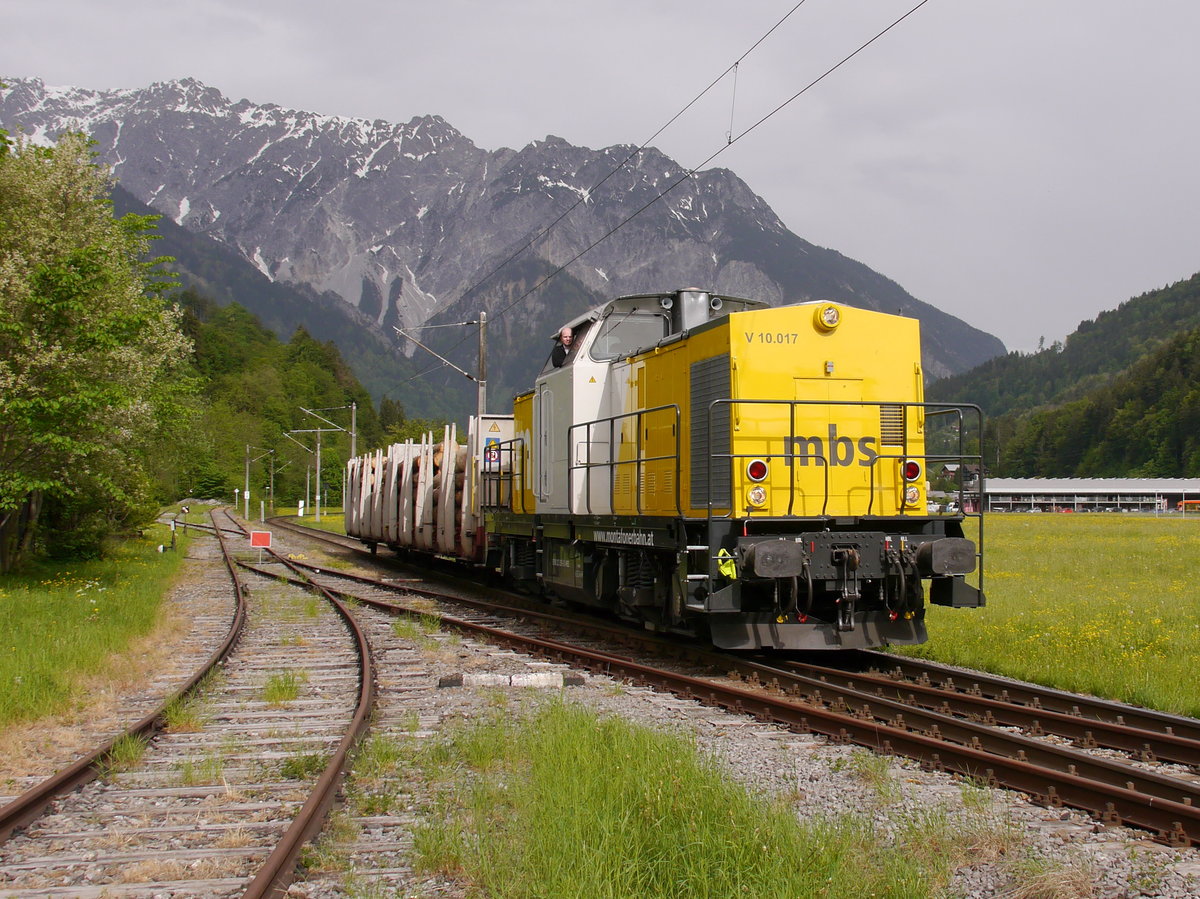 MBS V10.017 mit einem Güterzug bei Tschagguns unterwegs nach Schruns.
Die Lok trägt die NVR-Nummer 92 80 1203 159-9 D-MBS. Ja, wohlgemerkt die Lok trägt eine deutsche NVR-Nummer der MBS.
Ganz offensichtlich handelt es sich um eine in der DDR gebaute Lok des Typs  V100.1. Sie wurde 1972 bei LEW in Hennigsdorf unter der Fabriknummer 13485 gebaut und bei der DR als 110 446-2 in Dienst gestellt. Bei der DB AG wurde sie 1999 als 202 446-1 außer Dienst gestellt. Von ALS - ALSTOM Lokomotiven Service in Stendal wurde sie danach, gemäß dem Konzept  BR 203.1 , bis 2009 umgebaut und modernisiert. 
Das Gleis links auf der Wiese ist der stillgelegte und nach wenigen Metern demontierte ehemalige Anschluss zu den Illwerken in Tschagguns.

2016-05-11 Schruns-Rätikonstr Illabzweig