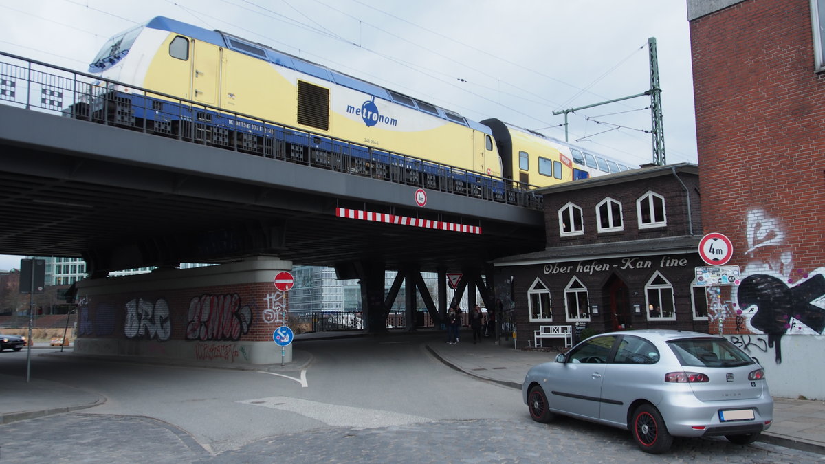 Metronom 81522 mit 246 004 als Schublok aus Cuxhaven musste warten, um in den Hamburger HBF einzufahren.
Zu dem Zeitpunkt lief ich gerade zum alten Güterbahnhof, um einen Flohmarkt zu besuchen, unter der Brücke an der  Oberhafen-Kantine  vorbei.

Hamburg, der 17.3.2017