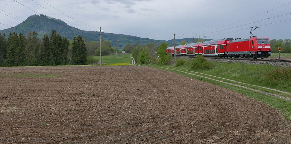 Mit Blick auf den Hausberg von Engen, dem 846 m.ü.M liegenden Hohenhewen, wurde bei Welschingen 146 206 aufgenommen, die den von Konstanz kommenden RE 4718 nach Karlsruhe schiebt (06.05.2017).