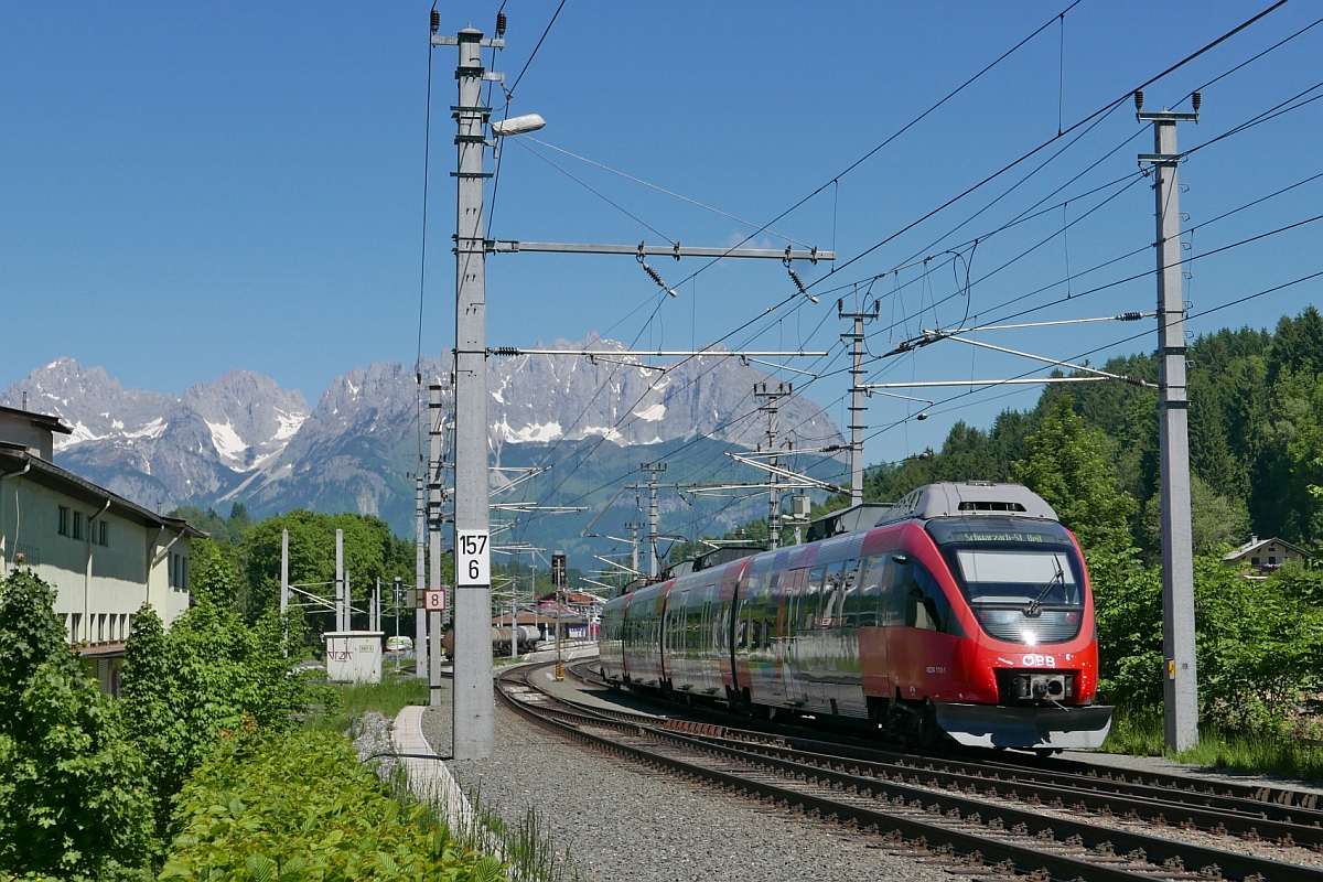 Mit Blick auf den mächtigen Wilden Kaiser fährt 4024 110-1 als REX 1513 von Wörgl nach Schwarzach St. Veit am 28.05.2017 in den Bahnhof von Kitzbühel ein.