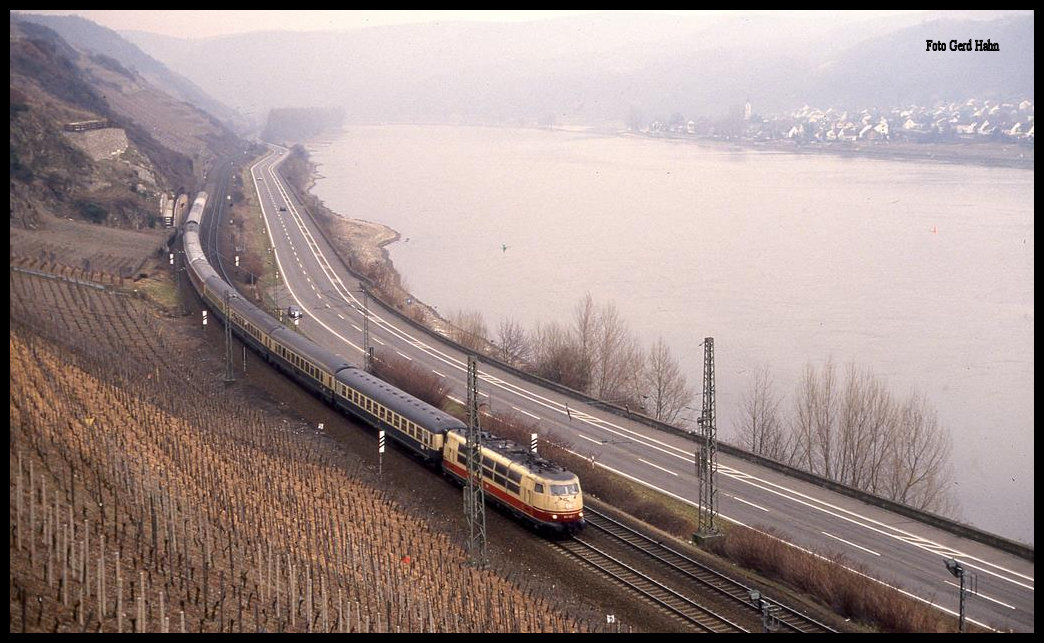 Mit einer bunt gemixten IC Garnitur war am 10.3.1993 um 10.58 Uhr die 103185 im Rheintal bei Boppard in Richtung Süden unterwegs.