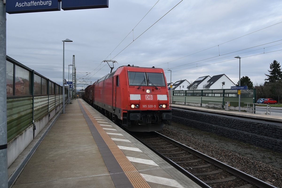 Mit einem Mischer am Haken ist die 185 320-9 in Nauheim von Bischofheim kommend gen Groß-Gerau fahrend. 7.1.2018