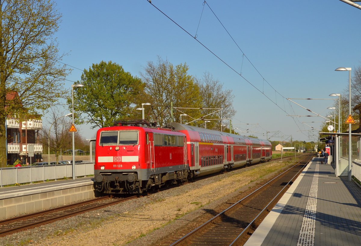 Mit einem Verstärker ist am Mittwochabend die 111 128 in Korschenbroich bei der Durchfahrt zu sehen, der Zug ist ein RE4 nach Aachen Hbf. 20.4.2016