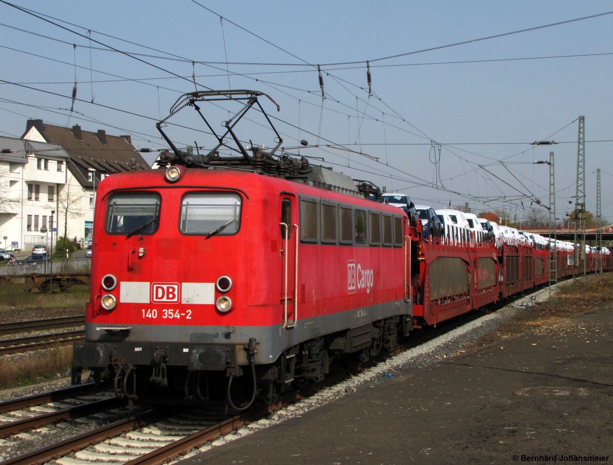 Mit einem VW Autozug fährt 140 354-2 durch den Bahnhof Löhne Richtung Osnabrück. April 2014