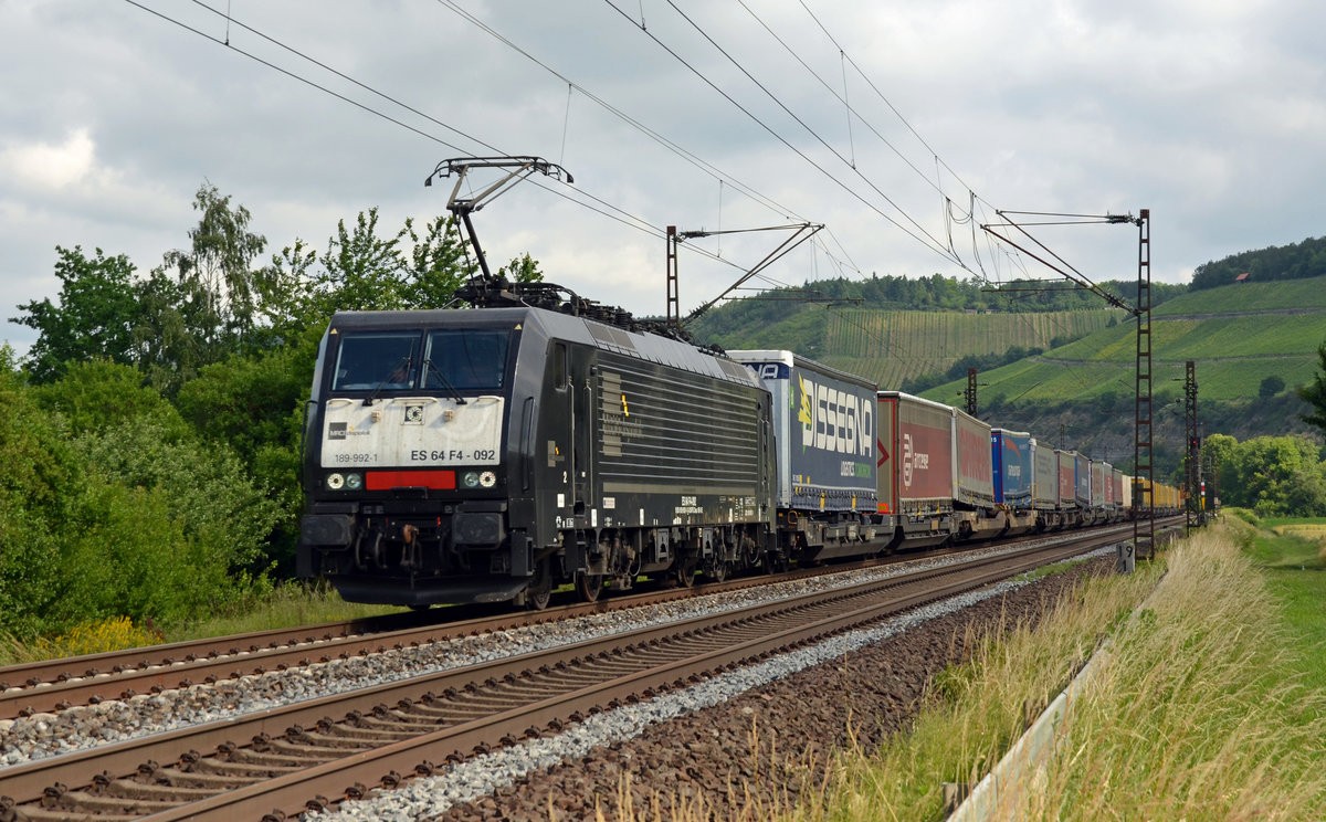 Mit einem Zug des kombinierten Verkehrs rollt die für TX fahrende 189 992 am 16.06.17 durch Himmelstadt Richtung Würzburg.