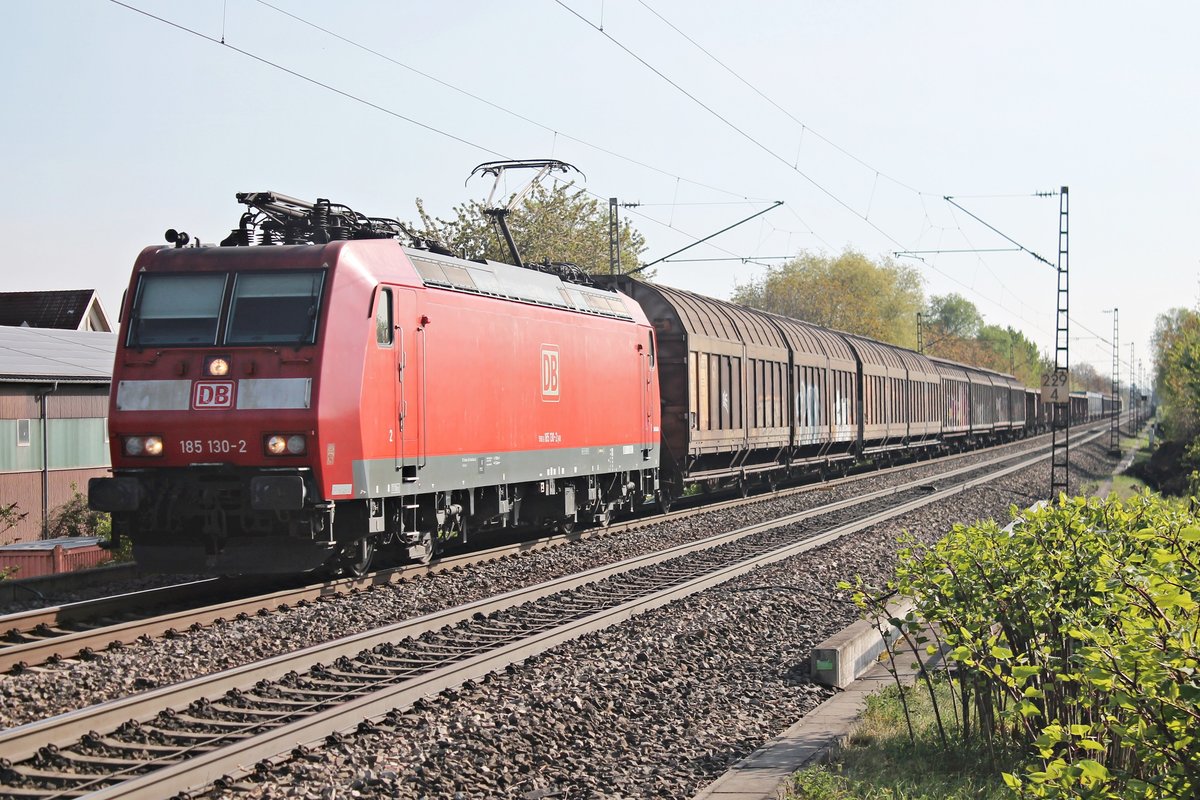 Mit Fernlicht und einem gemischten Güterzug nach Mannheim Rbf fuhr am 11.04.2017 die 185 130-2 bei Heitersheim durchs Markgräflerland in Richtung Bad Krozingen.