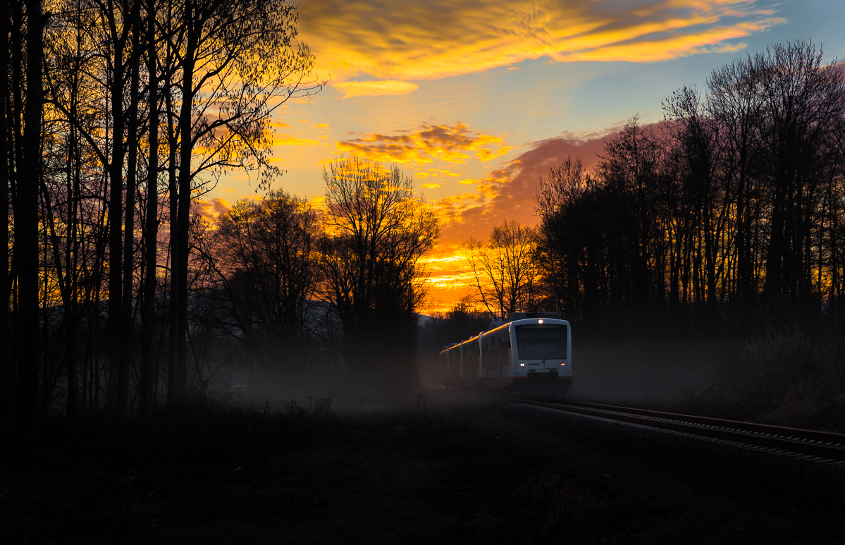 Mit der Morgenröte ist es immer so eine Sache: Gibt es eine, wann ist sie, fährt überhaupt ein Zug... Nachdem mehrere Tage beobachtet wurde, ob über dem Schwarzwald ein Paar lockere Wolken stehen, war es am Morgen des 18.März.2014 endlich so weit. 
Als ich an der Fotostelle ankam, tauchte die Breisgau S Bahn schon überpünktlich aus der Nebelbank auf. Und so wurde einige male ausgelöst, die Kamera wieder eingepackt, ein kurzer Umweg zum Becker gefahren und danach erst einmal in Ruhe gefrühstückt.