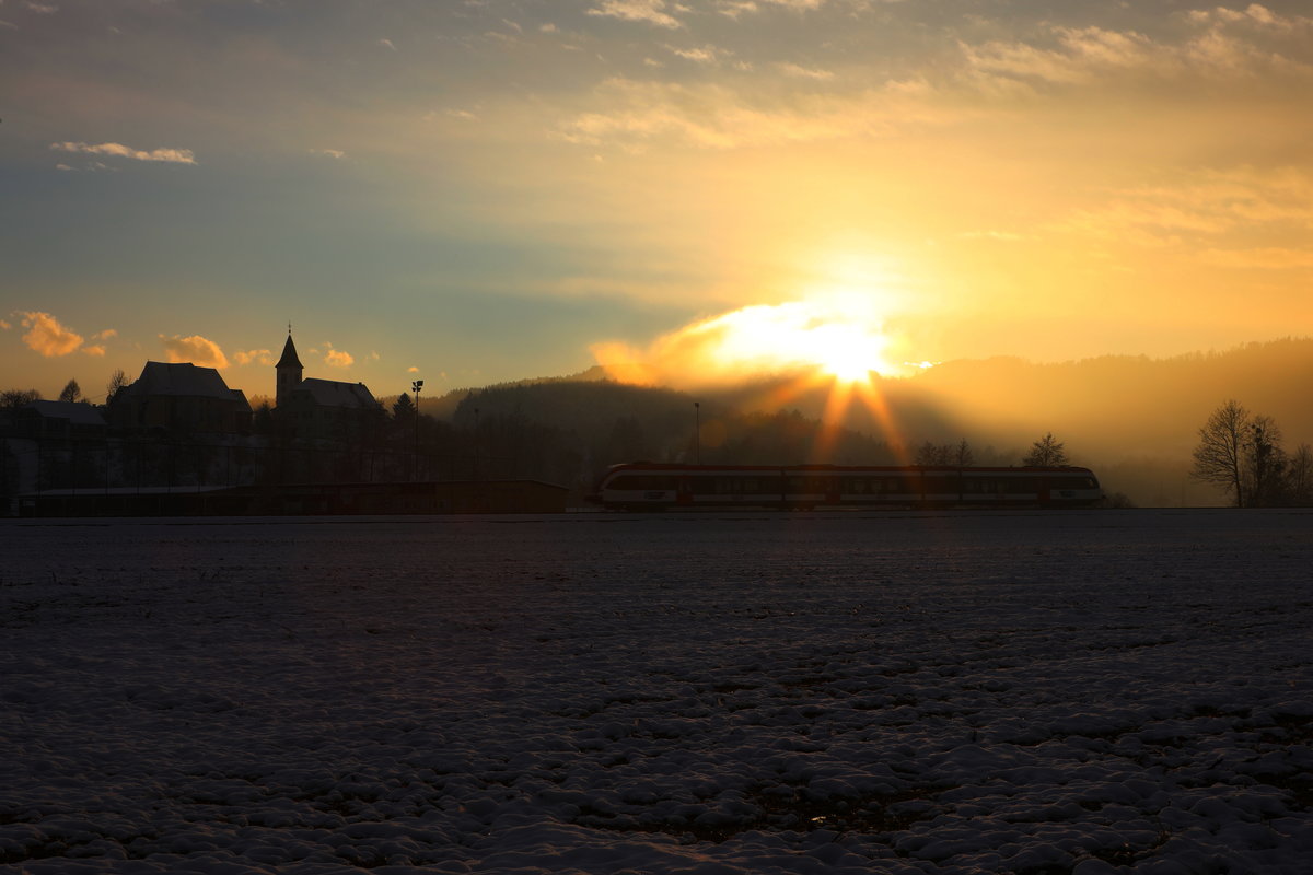 Mit der Untergehende Sonne flitzt ein Zug der Linie S6 vorbei an der Pfarrkirche St. Peter im Sulmtal. 

16.01.2018