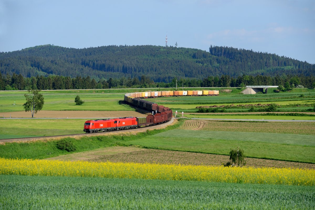 Mit VG 73145 ging es dann am 28. Mai 2015 für 2016.021 und 003 wieder zurück nach Schwarzenau. Mit 92 Achsen weist der Zug eine ordentliche Länge auf. Bei Sprögnitz schlängelt sich die Strecke durch weitläufige Felder, um dann in einem großen Waldgebiet zu verschwinden. Im Hintergrund erkennt man den Sendemasten bei Loschberg.