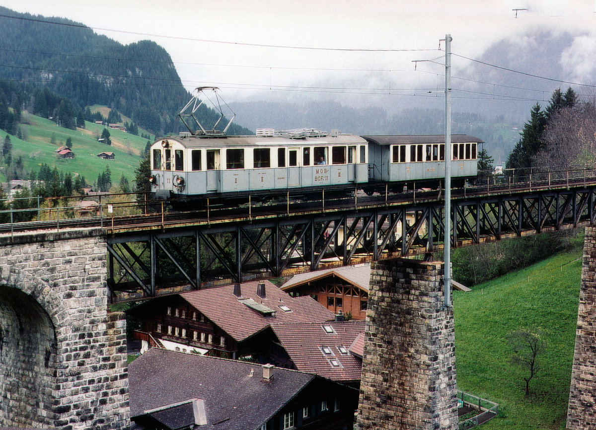 MOB: Der MOB Nostalgiezug aus dem Jahre 1905 der Museumsbahn Blonay Chamby mit BCFe 4/4 11 + BC 22  auf dem Viadukt Gstaad im Mai 2005.
Das über 100 Jahre alte Viadukt in der  Chäle  nur wenige Meter vom Bahnhof entfernt, gehört mit seiner Stahlkonstruktion zu den imposantesten Kunstbauten der MOB.
Foto: Walter Ruetsch