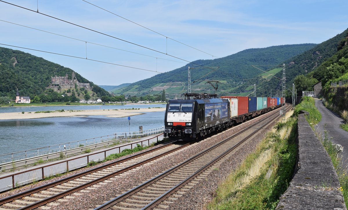 MRCE ES 64 F4-281 (E 189 281)  Bei uns kommen sie alle zusammen. , an TX Logistik vermietet, schleppt einen KLV-Zug am 07.07.17 auf der rechten Rheinstrecke bei Assmannshausen in Richtung Wiesbaden. Auf der anderen Rheinseite sind die Clemskapelle und Burg Reichenstein zu erkennen.