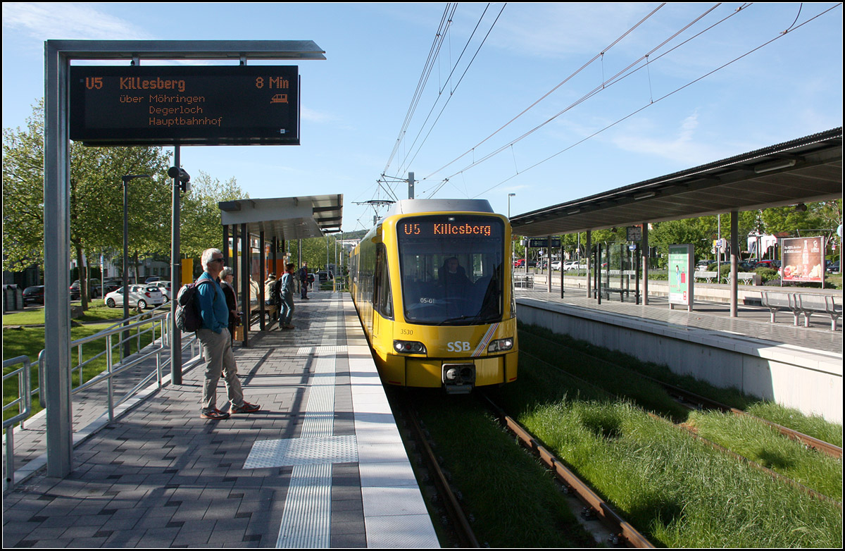 Neue Endhaltestelle der Stadtbahn in Leinfelden -

Neu gebaut wurde die Endstation der Stuttgarter Linie U5 in Leinfelden. Am Ankunftsbahnsteig (rechts) hält die Stadtbahn jetzt am gemeinsamen Bahnsteig mit der S-Bahn, ein Novum im Stutgarter Stadt- und S-Bahnnetz. Die bisherige Stadtbahnstation mit Mittelbahnsteig wurde aufgelassen. Gleichzeitig wurde im nördlichen Anschluss an die Haltestelle die Strecke für die Stadtbahn neu trassiert, sie liegt jetzt neben der S-Bahn. Die neue Station ist ein erster Bauabschnitt für eine Verlängerung der U5 zunächst um eine Station und später weiter bis nach Echterdingen, wohin der Straßenbahnlinie 6 vor der Umstellung auf Stadtbahnbetrieb bis 1990 schon fuhr.

20.05.2016 (M)