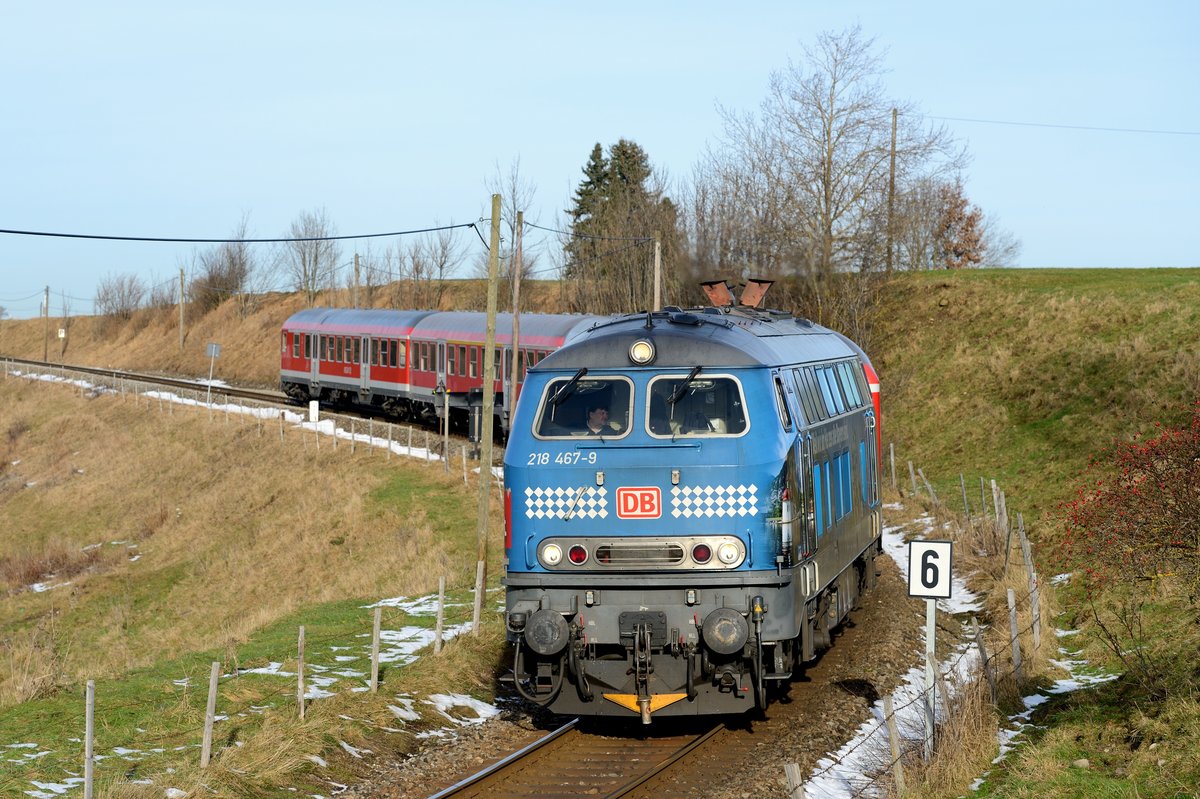 Noch eine größere Aufnahme der an den großen Erfolg des Bayern-Tickets erinnernden 218 467 vom Bh Kempten. Bei Leuterschach konnte sie mit Ihrem RE 57346 nach Füssen fotografiert werden. Eine Besonderheit auf dieser Strecke ist der signalisierte Zugleitbetrieb - das bedeutet, die Nebenbahn wird mit vereinfachter Leit- und Sicherungstechnik betrieben. Typisch dafür ist der am Triebfahrzeug befestigte Zugschlusssender, den man hier am Kupplungshaken der 218 467 hängend gut erkennen kann.