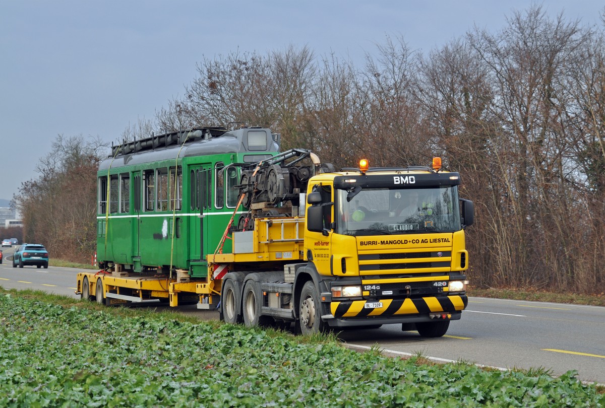 Nun ist der Be 4/4 460 an der Reihe. Am 18.12.2015 wird er in der Hauptwerkstatt aufgeladen und tritt die letzte Reise an. Hier fährt der Lastwagen auf der Rheinstrasse Richtung Augst.