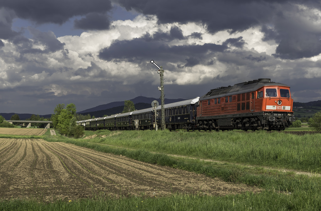 Nun mal ein erstes Bild nach langer zeit von mir. Für eine 232 fahre ich auch mal gerne weiter weg, so wie es am 14.05.2016 der Fall war. Und wenn ein Orientexpress zu bespannen ist sowieso. Die Wetterprognosen waren eher durchwachsen und ab Mittag war der Himmel so gut wie bedeckt. Also ich den Gedanken an ein Sonnenbild schon wieder verworfen. Stellung wurde am Einfahrsignal in Kothmaißling bezogen. Und hier hatte ich mal wieder besonderes Glück. Der Zug Kam  um die Ecke  und ein kleines Wolkenloch gab etwas Sonne frei, als 232 209 die Bühne betrat. So entstand eine bizarre Lichtstimmung, zwischen ausgeleuchteten Zug, schwarzen Wolken und dunklen Hintergrund. Hier zu sehen, die eben erwähnte 232 209 mit dem NF 13450 Prag - Calais.