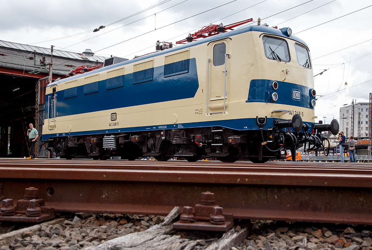 Nun wieder in der blau/beige Sonderlackierung des  Karlsruher Zuges , diesen trug sie von 1977 bis 2000...........
Die 141 248-5, ex DB E 41 248, wird am 20.08.2016 beim Lokschuppenfest vom Südwestfälischen Eisenbahnmuseums in Siegen vor dem Ringlokschuppen präsentiert. Nach nun nach 16 Jahren in „Verkehrsrot“ wieder  in der Sonderlackierung des  Karlsruher Zuges , so war sie früher auch sehr oft auf der Ruhr-Sieg und der Dill-Strecke zu sehen. Sie war auch die einzige in dieser Versuchslackierung zum Karlsruher Wendezug (grün-beige), diesen trug sie 1977 bis 2000.
 
Die Lok wurde 1963 von Henschel unter der Fabriknummer 30451 gebaut, der elektr. Teil von Brown, Boveri & Cie AG (BBC). Im Jahr 2003 wurde sie z-gestellt, heute ist sie Eigentum vom DB-Museum Nürnberg und eine Leihgabe an das Südwestfälisches Eisembahnmuseum (Bw Siegen).

Von 1977 bis 1995 war der  Knallfrosch  dem BW Hagen-Eckesey zugeteilt, im Januar 1977 erhielt sie den asymmetrischen S-Bahn-Versuchslack, der der allgemeinen ozeanblau-beigen Farbgebung ähnelt. Die Lok sollte immer mit der gleichen Seite an einem mit blauen Fensterband umgerüsteten Versuchszug der BD Essen aus umgebauten Silberlingwagen für den S-Bahn-Verkehr am Zug hängen, damit Lok und Wagen farblich harmonierten. Dieser Zug, der sogenannte „Karlsruher Zug“, war der Prototyp für die bis heute zahlreich eingesetzten S-Bahn-Züge, gebildet aus Lokomotiven der Baureihen 111 bzw. 143 und drei bis fünf x-Wagen.
