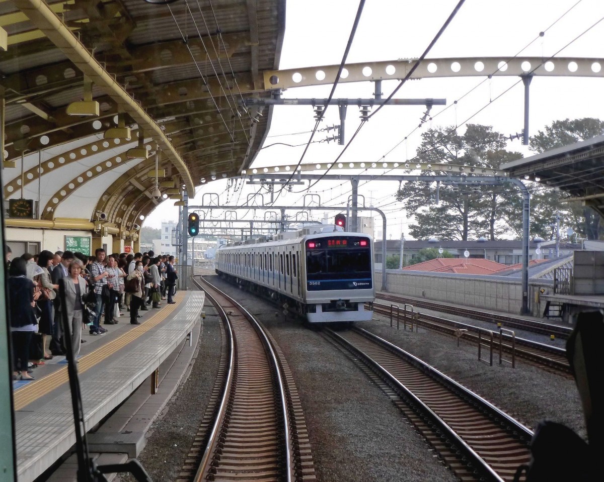 Odakyû Konzern, Serie 3000: Odakyû spielt im Berufs- und Pendlerverkehr im Südwesten des Grossraums Tokyo eine zentrale Rolle. Die Hauptstrecke von Tokyo nach Odawara ist 82,5 km lang, mit weiteren Strecken zusammen betreibt der Konzern 126,8 km Strecke, dazu fahren einzelne Kurse über die U-Bahn (Tokyo Metro) 22 km unter Tokyo hindurch in den Norden der Stadt. Züge ganz verschiedener Geschwindigkeiten folgen sich im Minutentakt; im Bild aus dem haltenden Zug sieht man gerade den etwas schnelleren (Zug 3262) beim Ueberholen. Tokyo-Gôtokuji, 12.Oktober 2011.