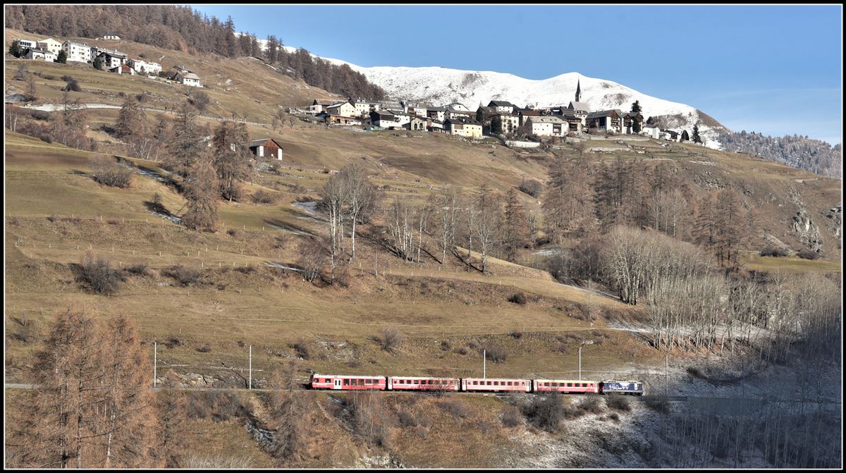 R1940 mit Ge 4/4 II 627  Reichenau-Tamins  zwischen Lavin und Guarda. Guarda cumün oben am Berg profitiert von der erhöhten sonnigen Lage. (28.11.2018)