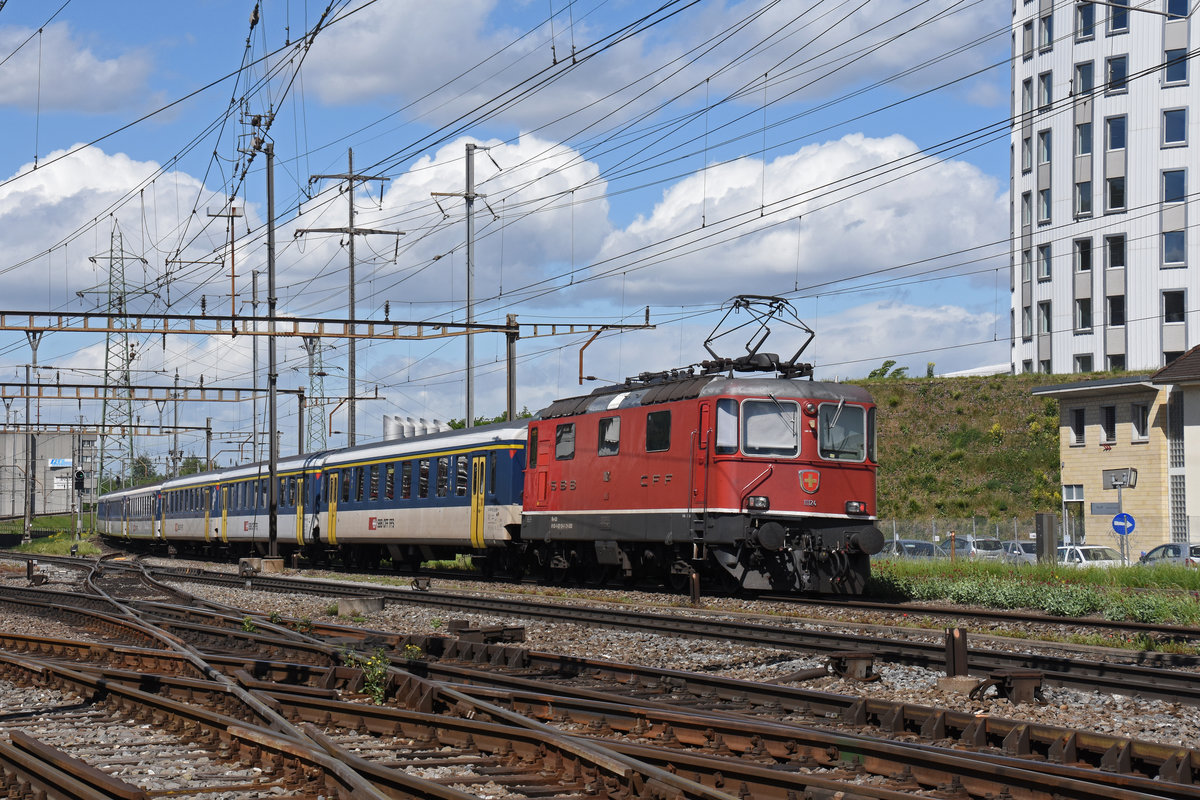 Re 4/4 II 11124 fährt Richtung Bahnhof Muttenz. Die Aufnahme stammt vom 30.04.2018.