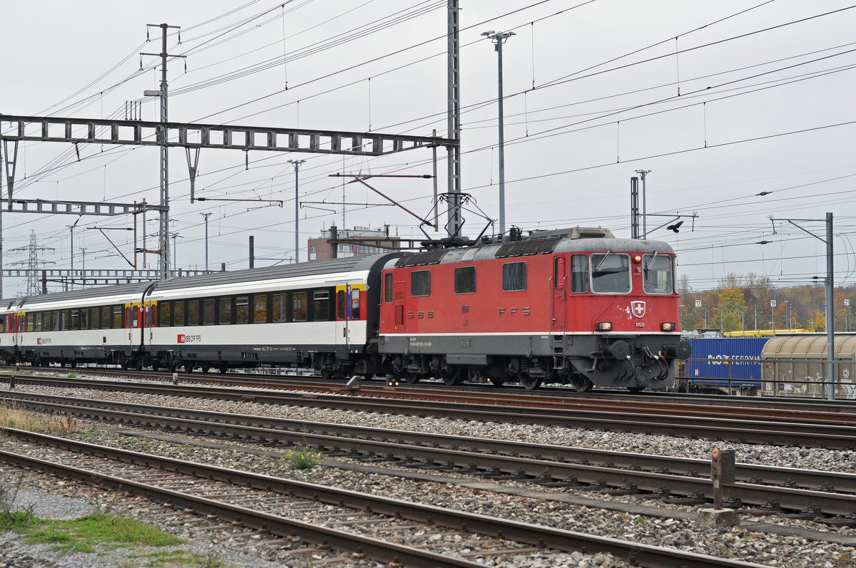 Re 4/4 II 11128 durchfährt den Bahnhof Muttenz. Die Aufnahme stammt vom 09.11.2017.