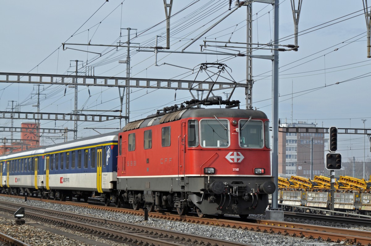 Re 4/4 II 11141 durchfährt den Bahnhof Muttenz. Die Aufnahme stammt vom 13.02.2015.