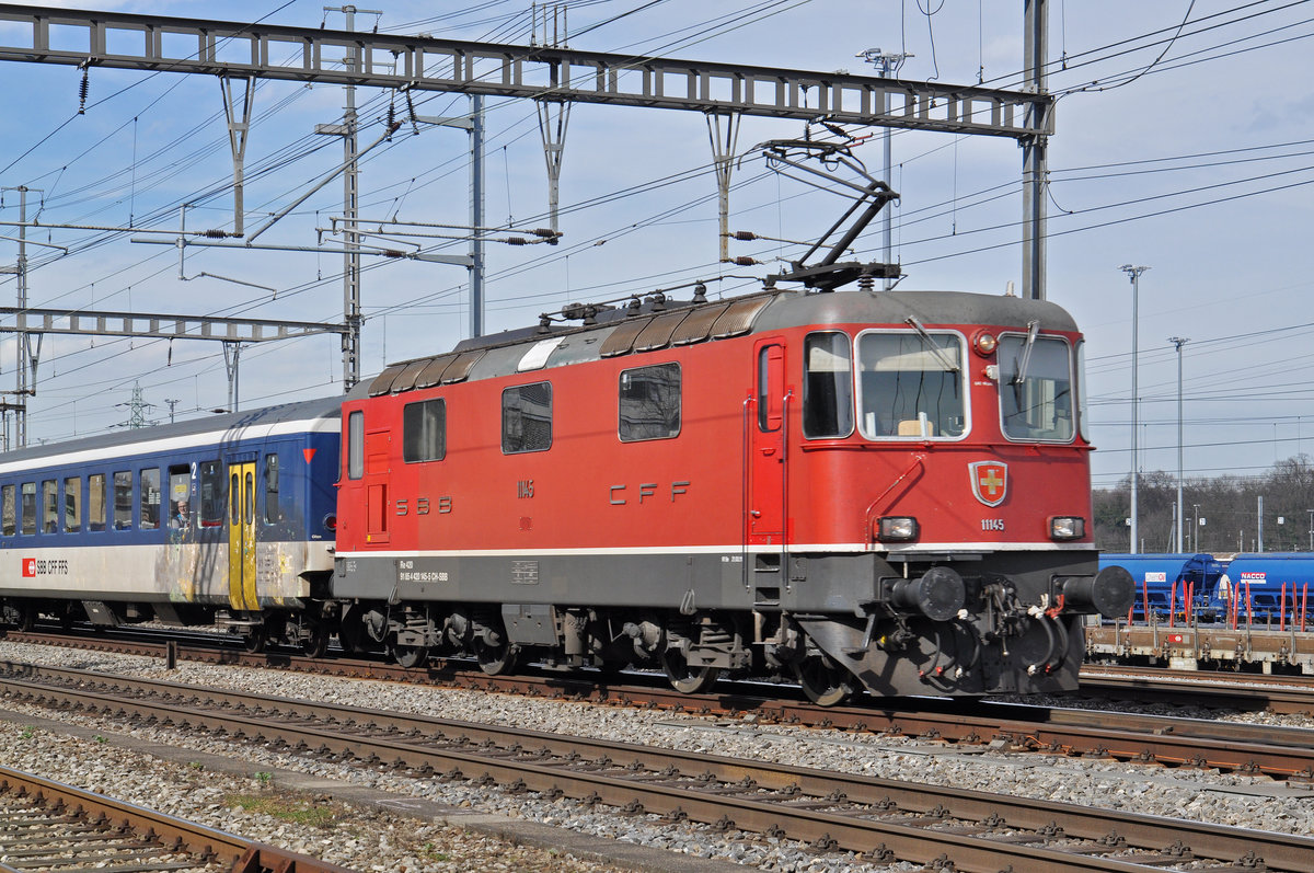 Re 4/4 II 11145 durchfährt den Bahnhof Muttenz. Die Aufnahme stammt vom 04.03.2017.