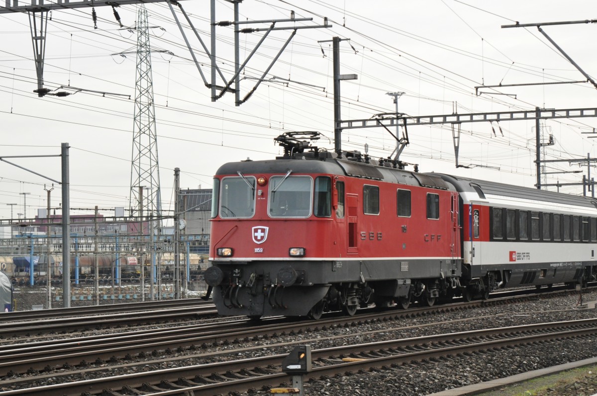 Re 4/4 II 11159 durchfährt den Bahnhof Muttenz. Die Aufnahme stammt vom 28.01.2015.