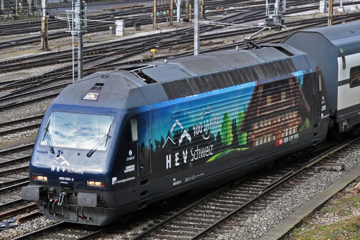 Re 460 023-5 mit der Werbung für das 100 jährige bestehen des Hauseigentümer Verbandes HEV verlässt den Bahnhof SBB. Die Aufnahme stammt vom 28.02.2015.