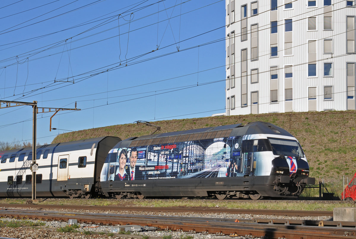 Re 460 028-4, mit einer Personalwerbung, durchfährt den Bahnhof Pratteln. Die Aufnahme stammt vom 28.11.2016.