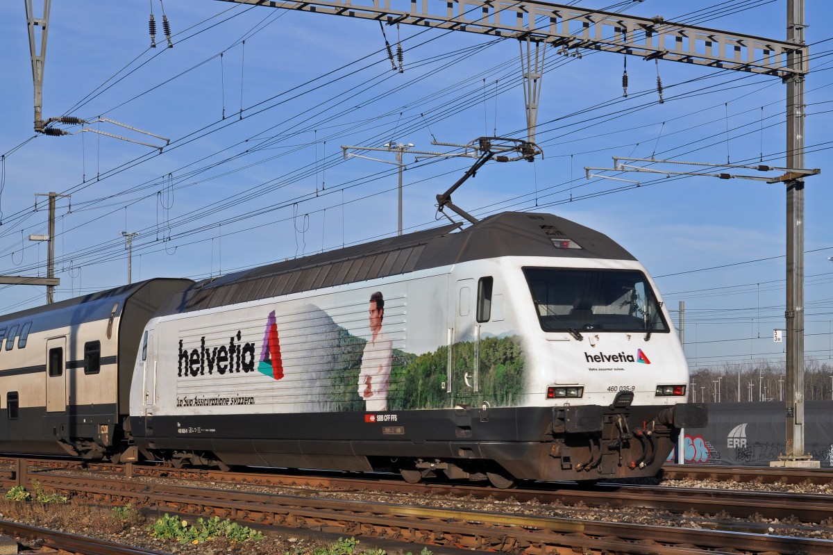 Re 460 035-9, mit der Helvetia Werbung mit Roger Federer, durchfährt den Bahnhof Muttenz. Die Aufnahme stammt vom 28.12.2015.