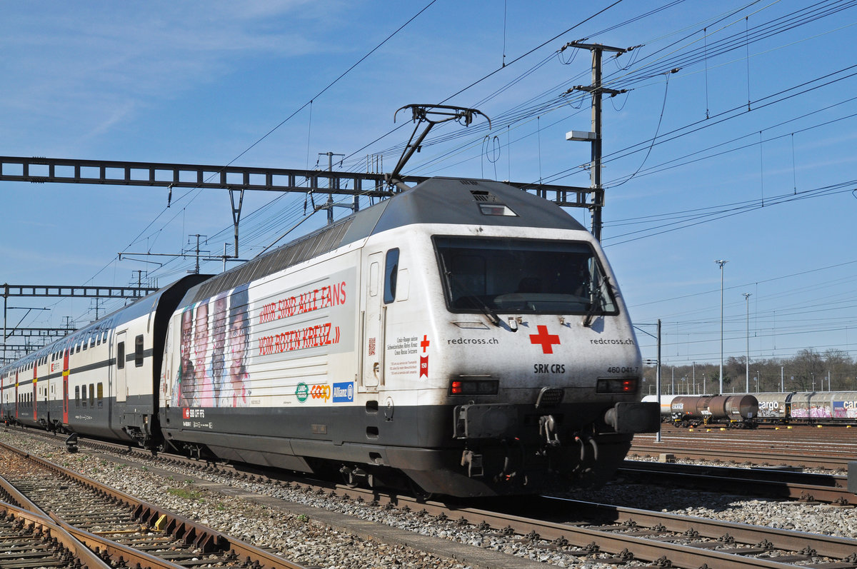 Re 460 041-7, mit der Rotkreuz Werbung, durchfährt den Bahnhof Muttenz. Die Aufnahme stammt vom 10.03.2017.