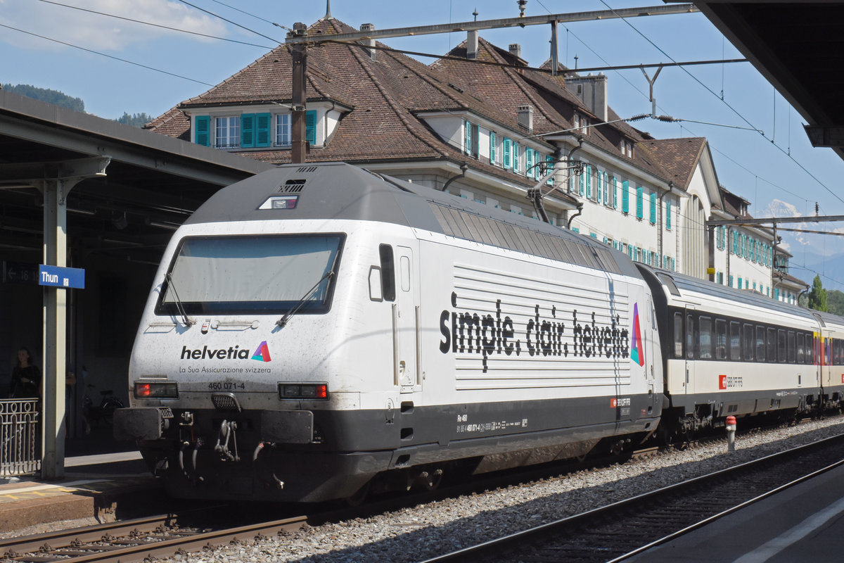 Re 460 071-4, mit der Helvetia Werbung, wartet beim Bahnhof Thun. Die Aufnahme stammt vom 30.07.2018.