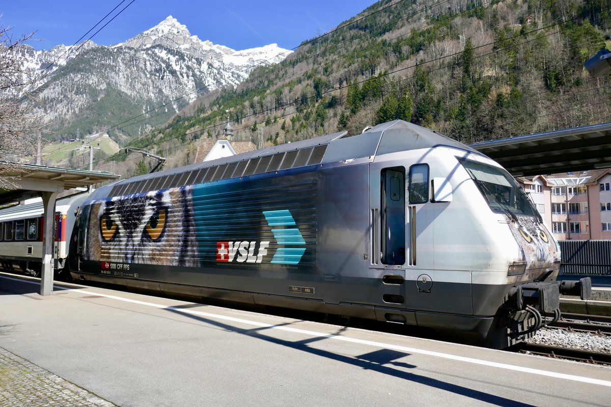 Re 460 105 mit VSLF Werbung vor der Abfahrt mit dem Gotthard Panorama Express nach Lugano, am 2.4.18 im Bhf Flüelen.