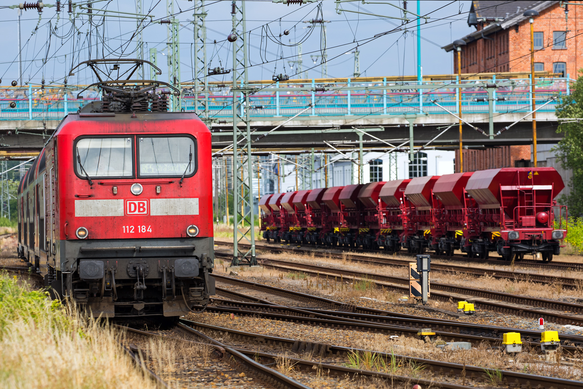 RE 5 nach Stralsund fährt in Neubrandenburg an Offene Schüttgutwagen vorbei. - 30.06.2016