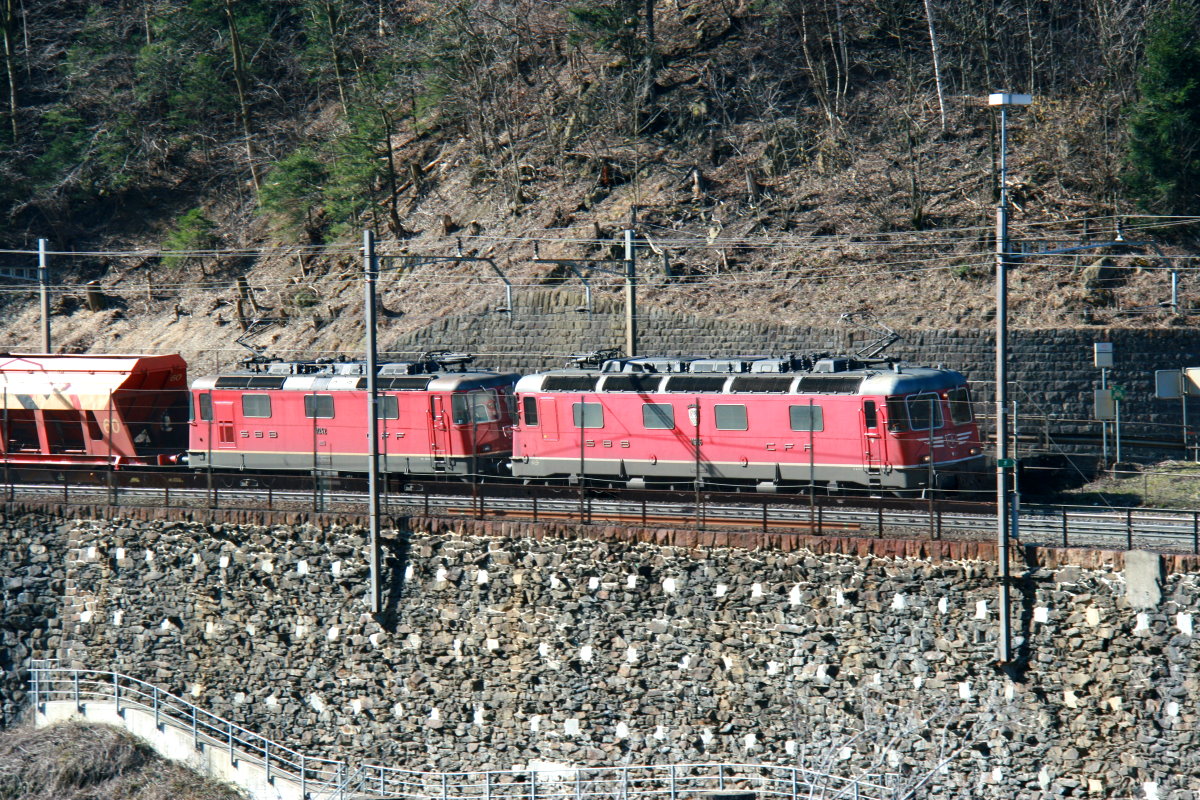 Re 6/6 11626 und Re 4/4 11242 vor einem Schüttgutganzzug auf der Gotthard-Nordrampe oberhalb von Amsteg; 07.03.2015