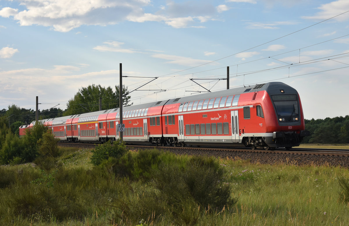 RE1 des Hanse-Express nach der Abfahrt vom Bahnhof Büchen, unterwegs nach Schwerin. Schiebelok war die 120 205-0. 3km östlich von Büchen, 30.07.2018. 
