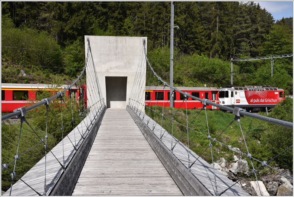 RE1748 mit Ge 4/4 II633  Zuoz  passiert die neue Fussgänger-Hängebrücke über den Vorderrhein in Trin. (15.05.2016)