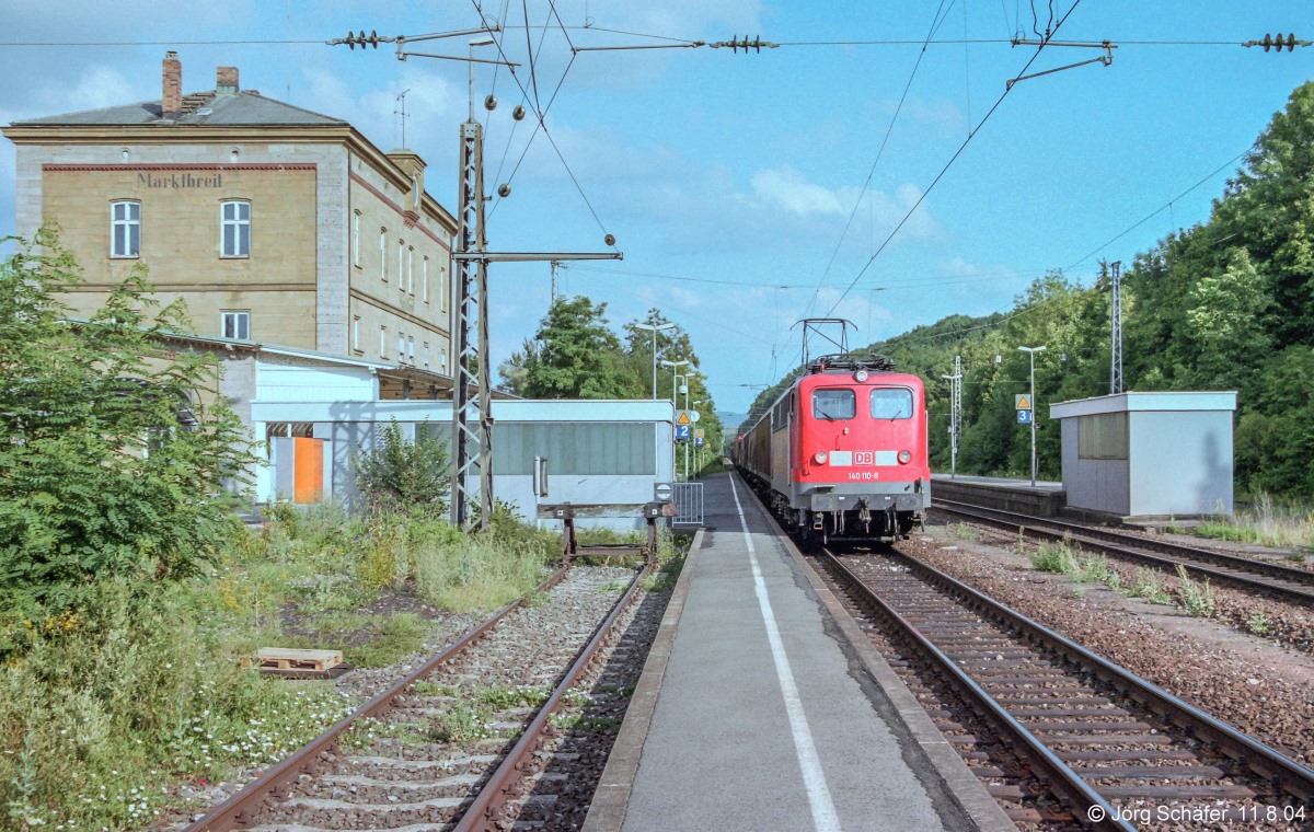 Recht eintönig war der Betrieb in Marktbreit am 11.8.04, als 140 110 mit einem Güterzug nach Würzburg durchfuhr. Neben den beiden Hauptgleisen gab es nur noch das Stumpfgleis 1, alle anderen waren dem Mehorn’schen Sparwahn zum Opfer gefallen. 