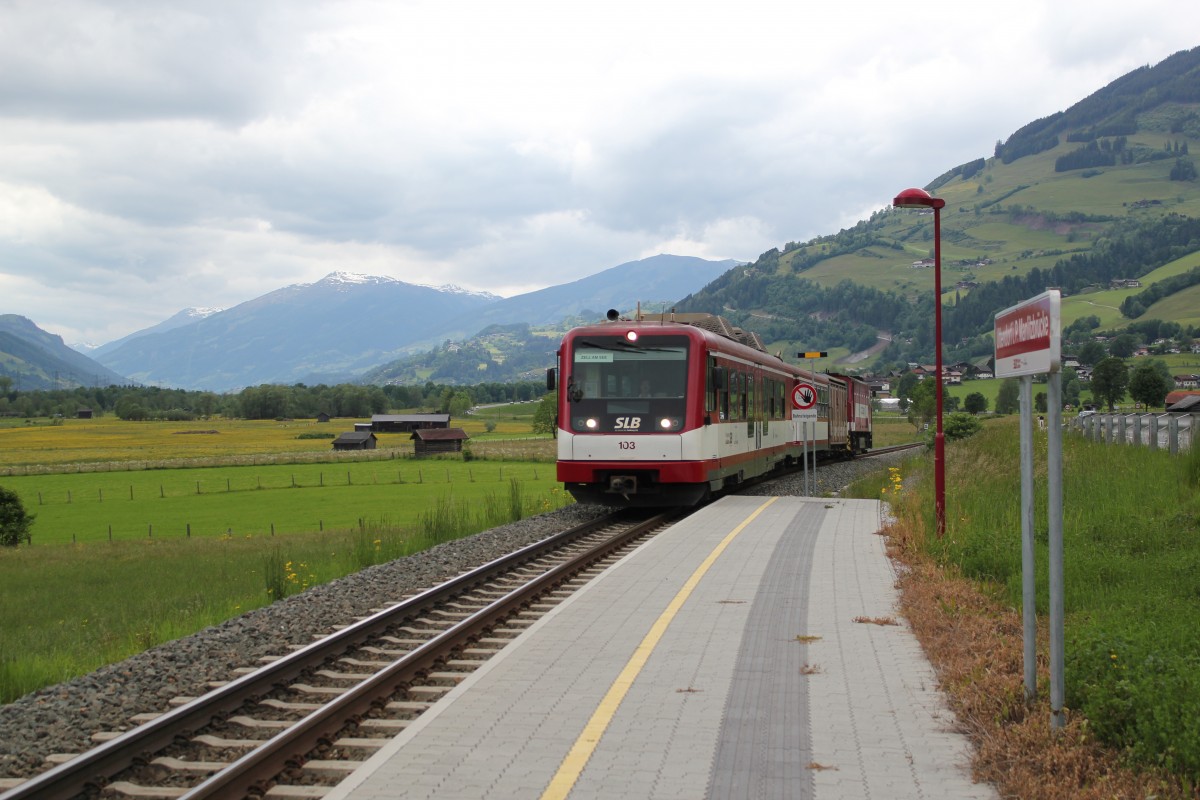 Reisezugwagen Vss 103 mit dem Triebwagen Vs 81 am Zugende bei der Einfahrt in die Haltestelle Uttendorf Manlitzbrücke. Die Aufnahme entstand Ende Mai 2014 mit Blick auf das obere Salzachtal. 