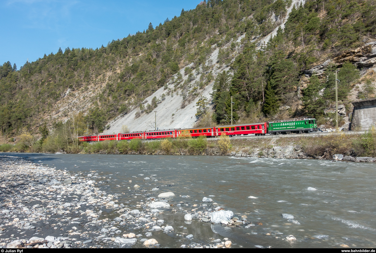 RhB Ge 4/4 II 621 mit Werbung für Traveco am 20. April 2018 mit einem RE Disentis - Scuol-Tarasp bei Trin.