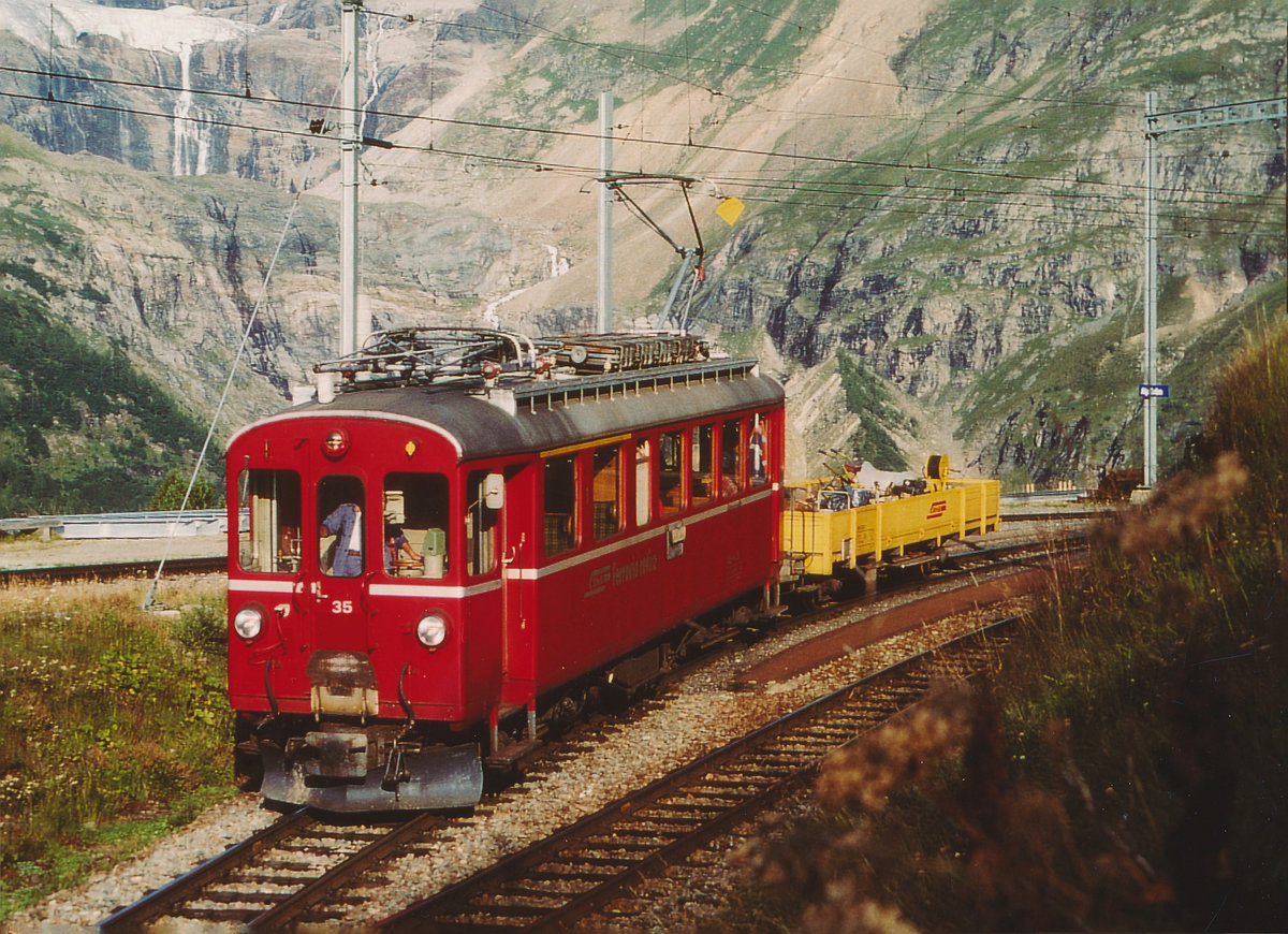 RhB/BC: Bauzug mit dem ABe 4/4 35 unterhalb des Bahnhofs Alp Grüm im August 2003. Die ABe 4/4 35-36 wurden erstmals im Jahre 1909 dem Betrieb übergeben und in den Jahren 1950-1951 modernisiert.
Seit dem Jahre 2010 steht dieser einzige noch mit dem roten Farbanstrich erhaltenen Original-Bernina-Triebwagen dieser Bauart in der Westschweiz bei der Museumsbahn Blonay-Chamby im Betrieb.
Foto: Walter Ruetsch
