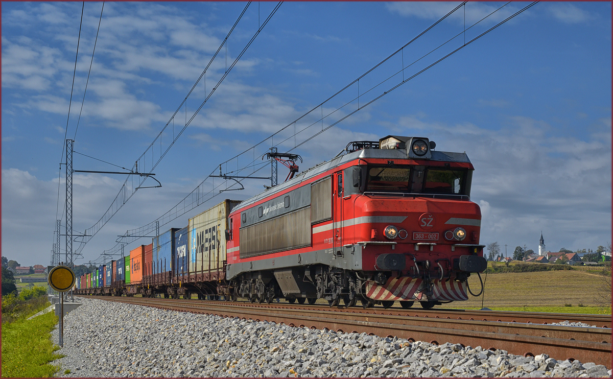 SŽ 363-002 zieht Containerzug an Črešnjevec vorbei Richtung Norden. /4.10.2017