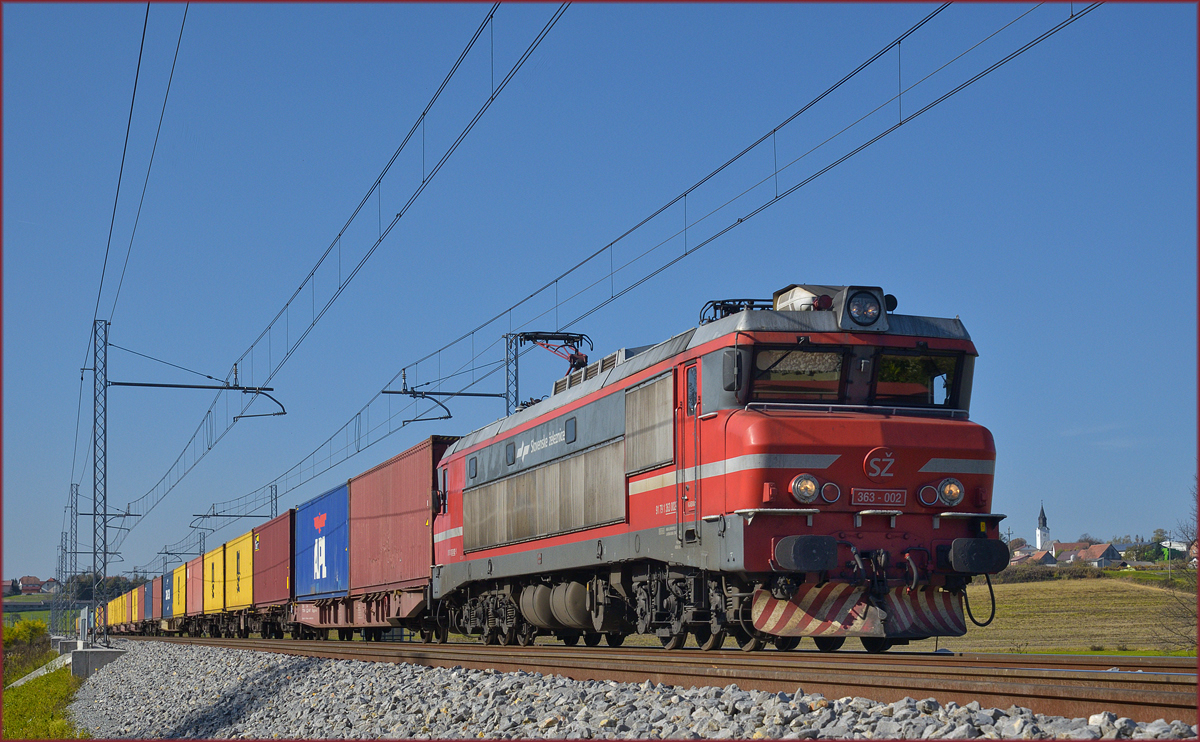 SŽ 363-002 zieht Containerzug an Črešnjevec vorbei Richtung Norden. /20.10.2017